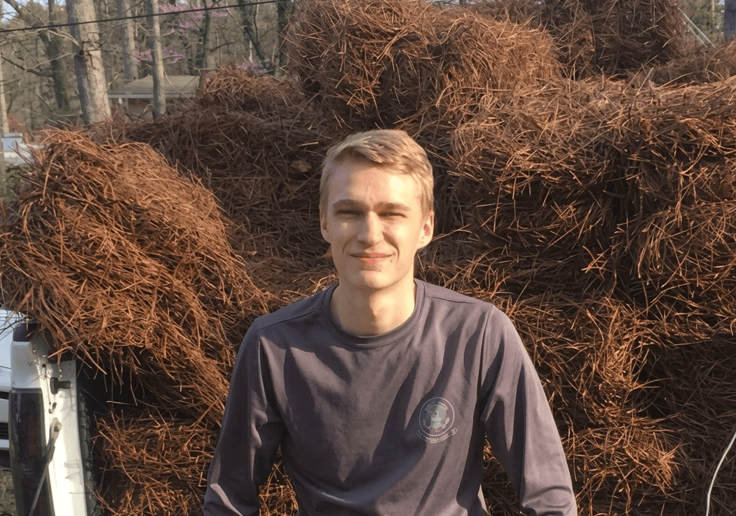 Will, founder of Village, with a load of pine straw bales