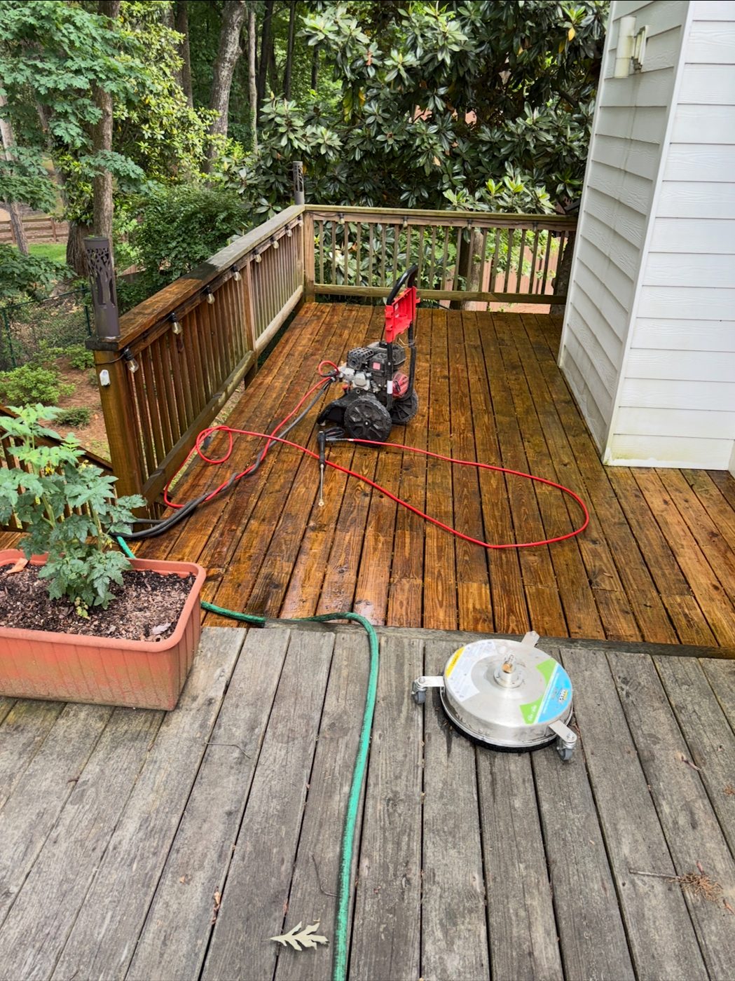 Mid-job on a Sandy Springs deck — the washer and surface cleaner drawing the line between before and after.